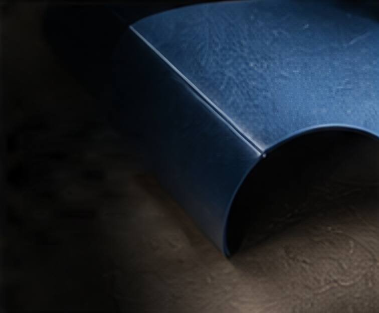 A folded deep blue structure resting on a textured surface.