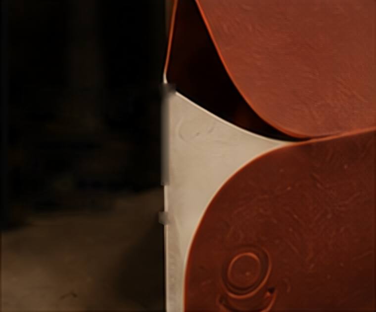 Two curved terracotta panels meeting a strip of uncoated white board.