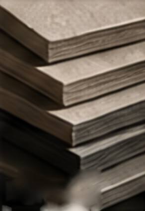 A stack of thick grey board sheets seen edge-on.