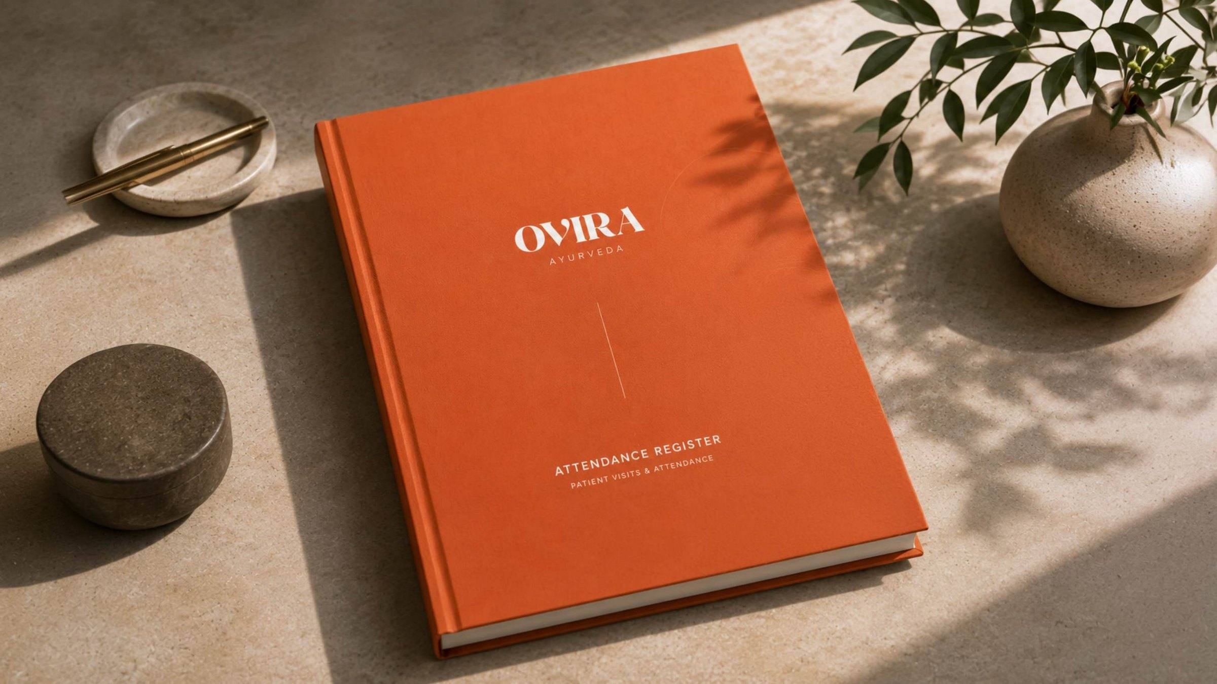 Ovira Ayurveda attendance register with a terracotta cover.