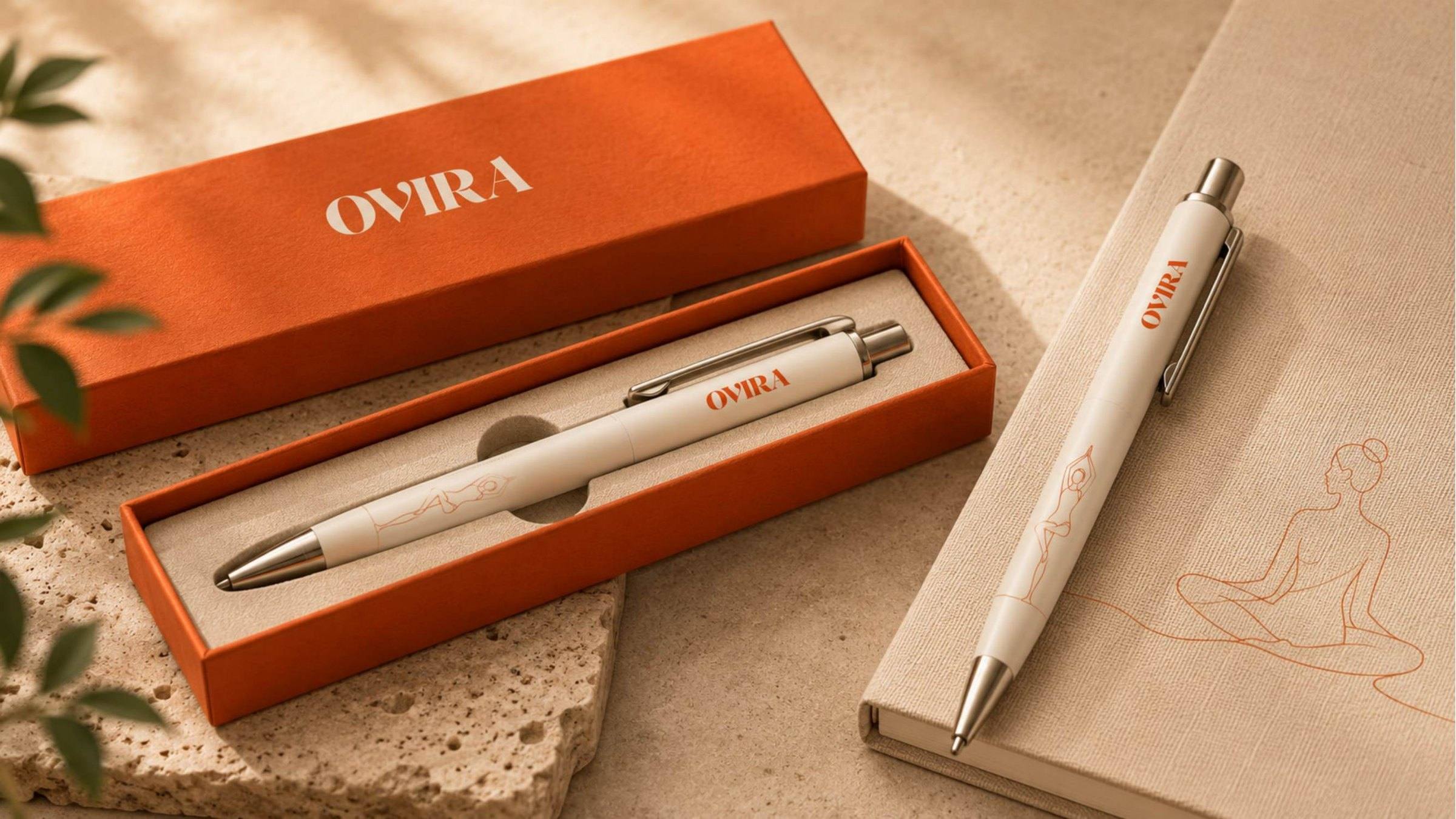 Ovira Ayurveda branded pen in a terracotta gift box beside a notebook.