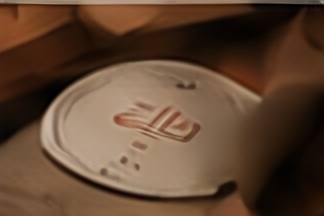A round Zila coaster on a wooden table.